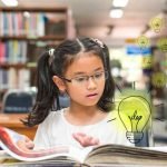 Girl in library practicing her reading.