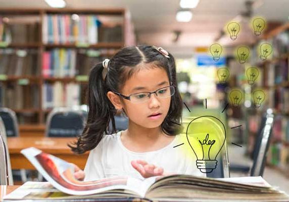 Girl in library practicing her reading.